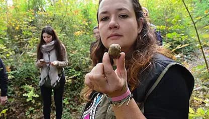 The truffle hunter Francesca holding a freshly found truffle during a truffle-hunting experience in the Tuscan woods.